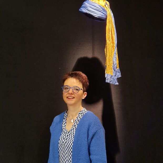 Christine Kullen steht unter der Kopfbedeckung des Gemäldes "Das Mädchen mit dem Perlohring" bei der Vermeer-Ausstellung im Frühling 2025