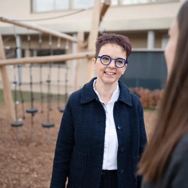 Christine Kullen im Gespräch mit einer Mutter auf dem Spielplatz.