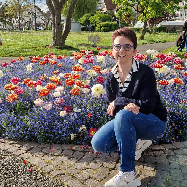 Christine Kullen vor Frühlingsblumen im Park in Langenargen am Bodensee Frühling 2025