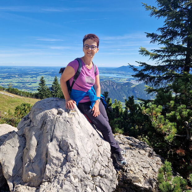 Christine Kullen sitzt auf einem Felsen bei einer Wanderung im Allgäu im Sommer 2025