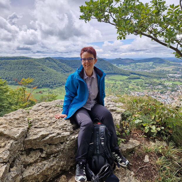 Christine Kullen sitzt auf einer Anhöhe bei einer Wanderung rund um Beuren Herbst 2025
